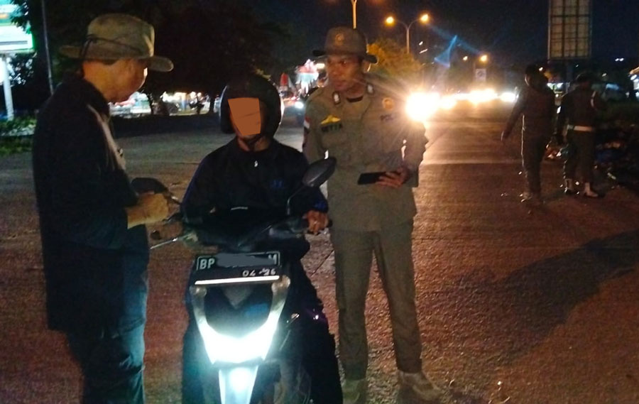 Petugas DLH saat melakukan razia warga yang buang sampah sembarangan.
