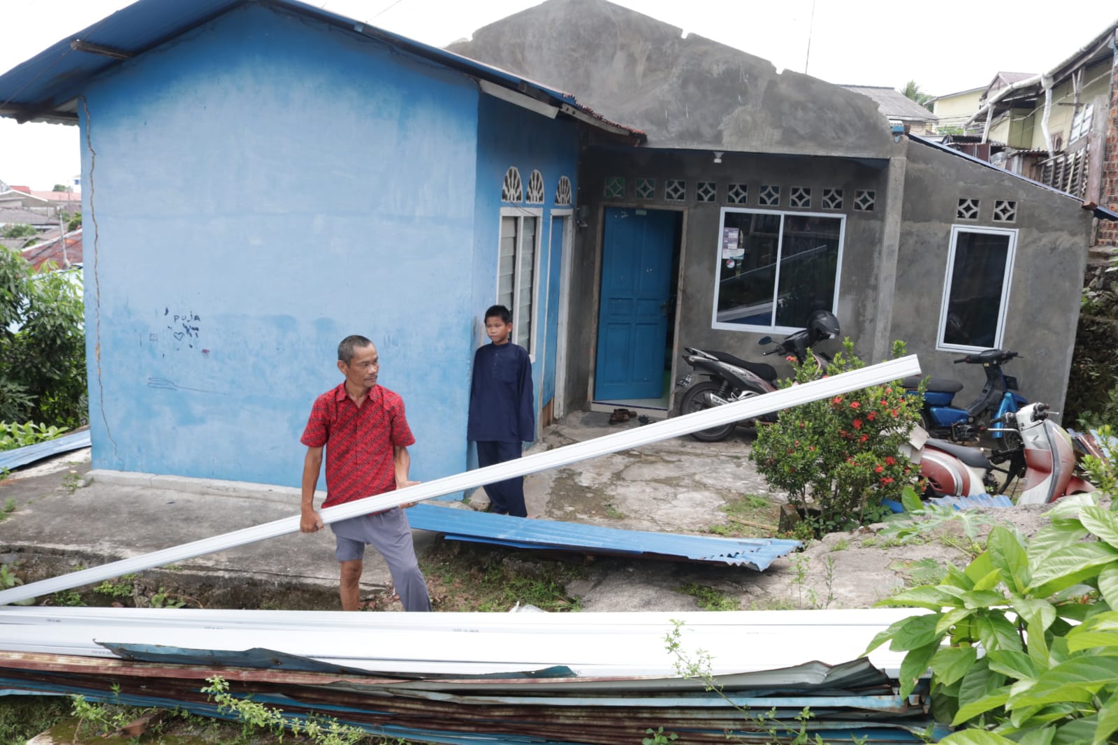 Ali, saat menerima bahan bangunan buat perbaikan atap rumah miliknya, Jumat (4/10).