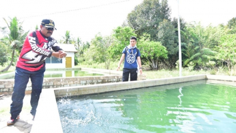 Bupati Karimun Aunur Rafiq mencoa kehangatan air di kolam pemandian air panas Tanjung Hutan.