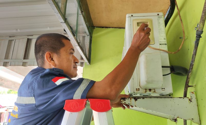Muhammad Yazid mengecek kerusakan mesin AC di Batu 5 Tanjungpinang.