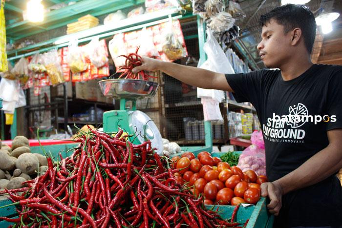 Seorang pedagang menimbang cabai merah yang dibeli konsumen di Batam.