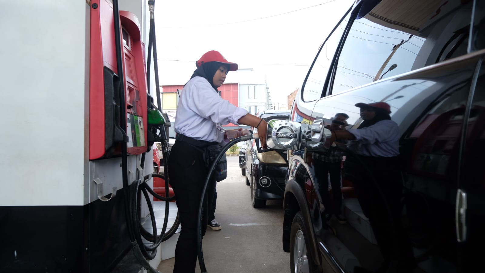 Petugas SPBU Jalan Sei Carang Tanjungpinang saat mengisi BBM pertalite ke Mobil konsumen, Jumat (15/11).