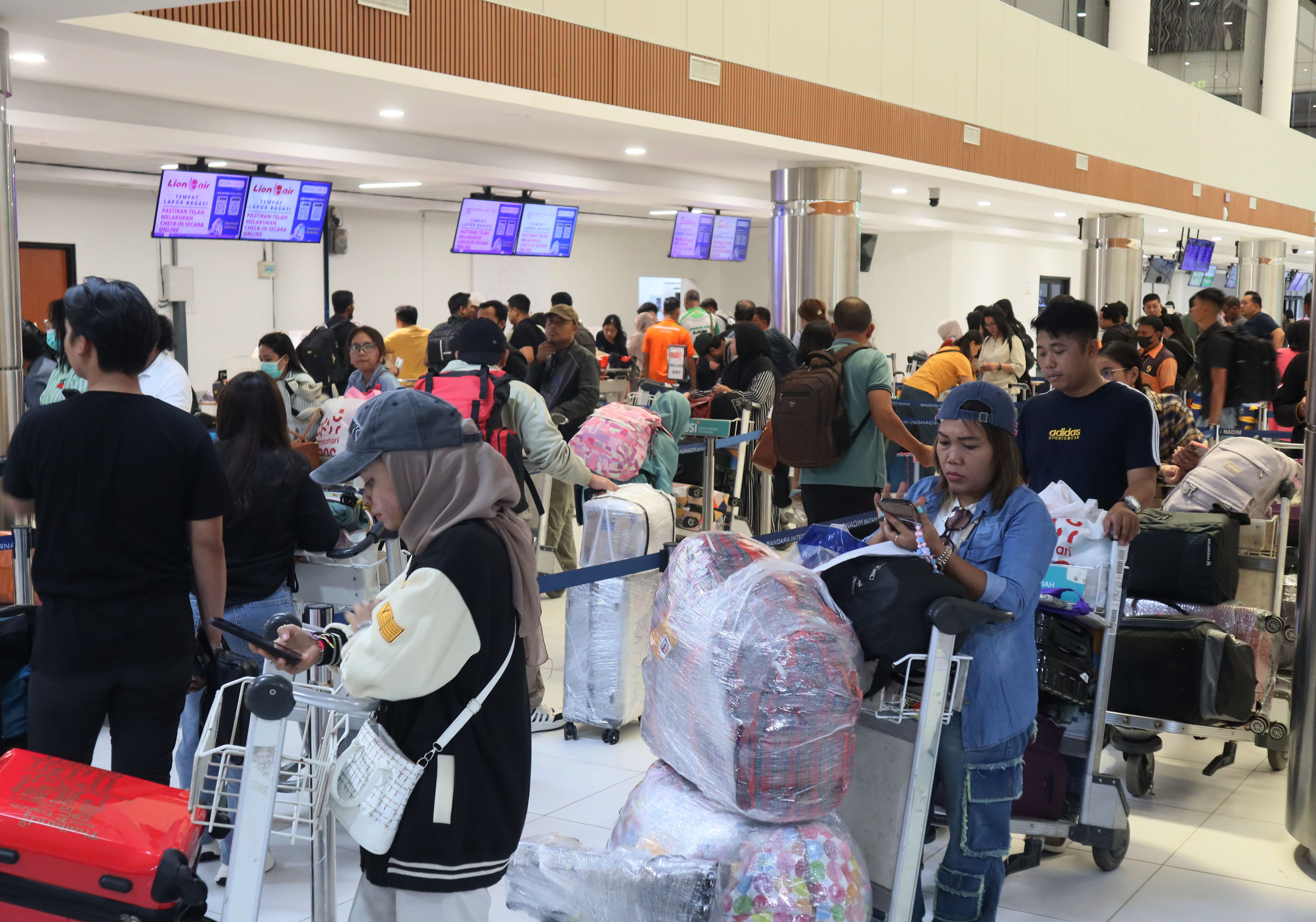enumpang melakukan check-in di terminal keberangkatan Bandara Internasional Hang Nadim Batam, Minggu (22/12). Menjelang Natal dan Tahun Baru arus penumpang mengalami peningkatan.