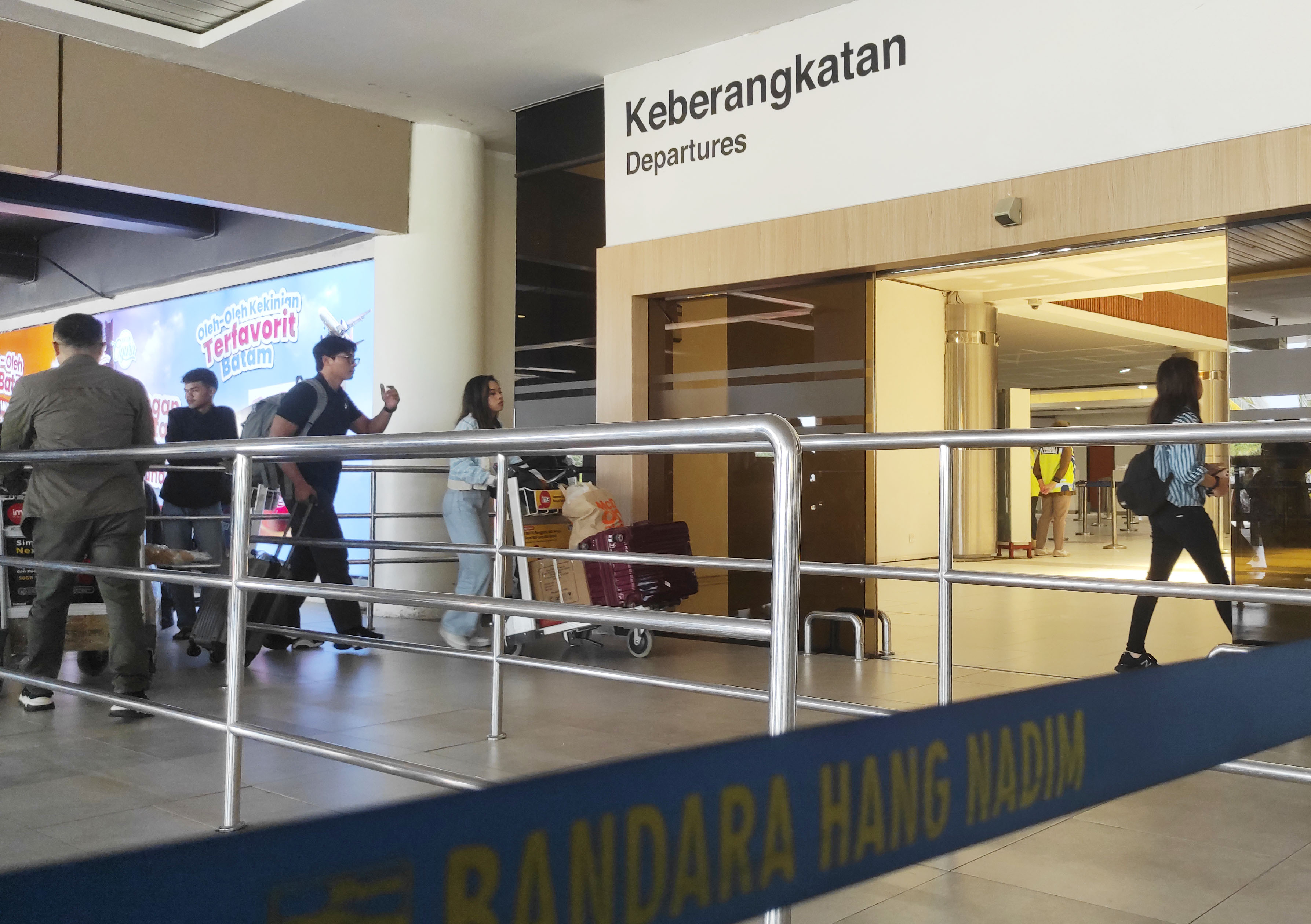 Penumpang yang akan melakukan penerbangan memasuki pintu keberaangkatan Bandara Internasional Hang Nadim Batam, Jumat (27/12).