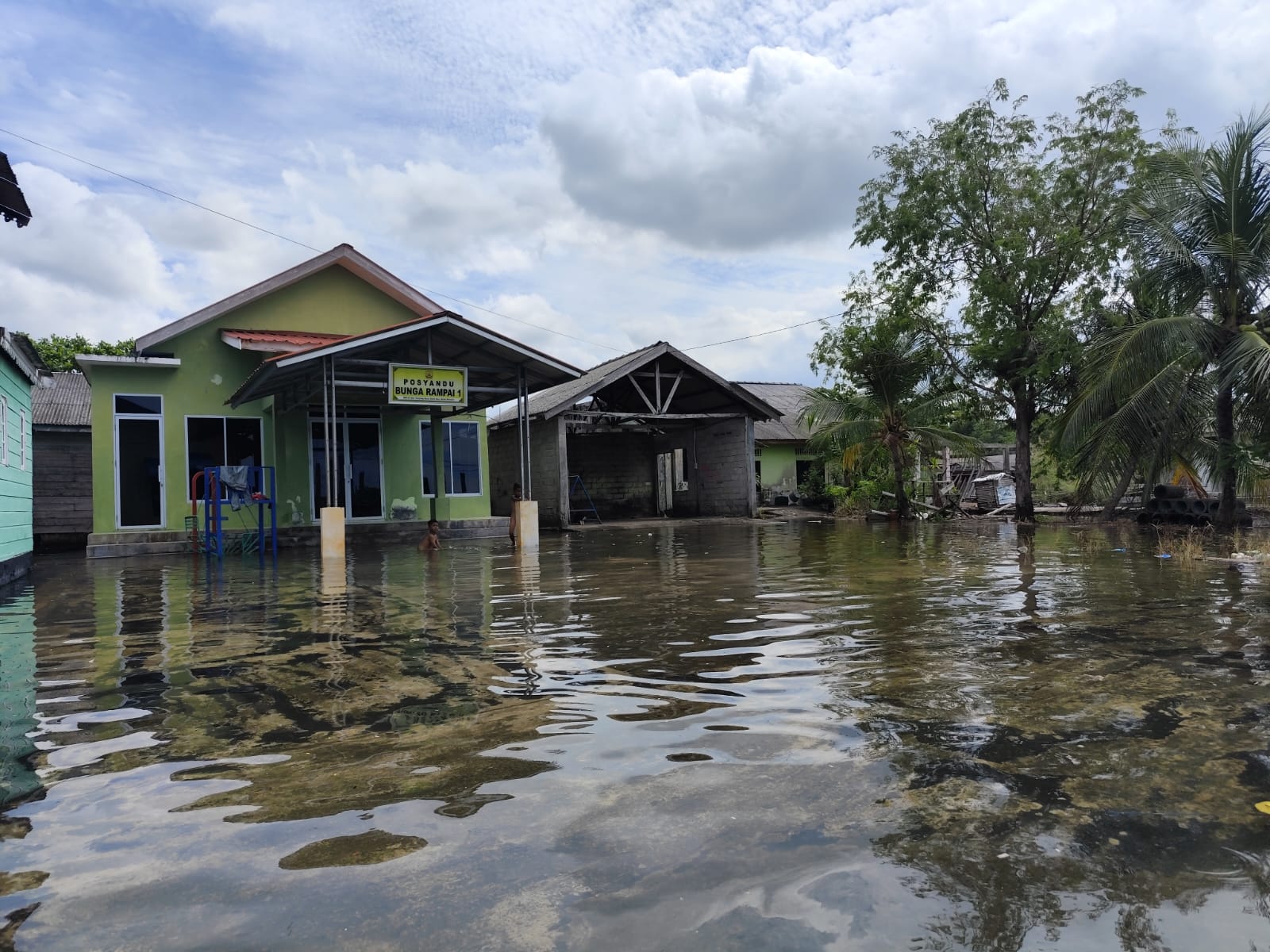 Anak-anak saat bermain air banjir rob di depan Posyandu Bunga Rampai 1 Jalan Lembah Purnama Tanjungpinang, Kamis (2/12).