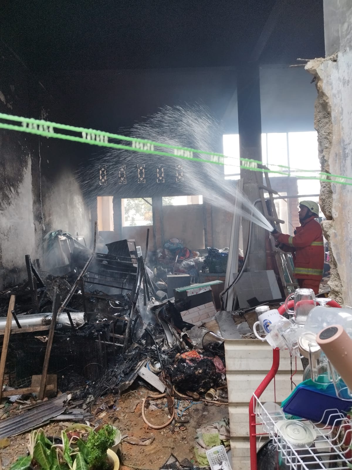 Petugas Damkar saat memadamkan api yang membakar isi rumah direnovasi di Tanjungpinang, Minggu (5/1).