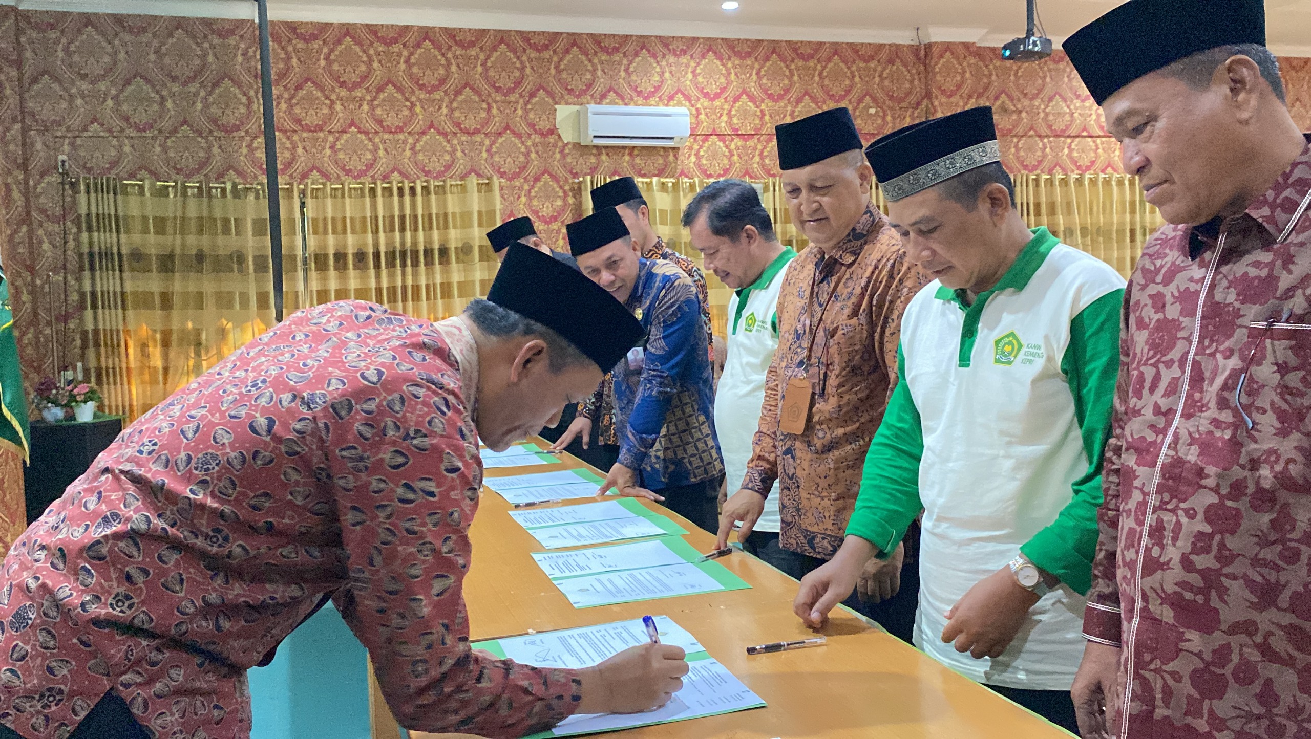 Kakanwil Kemenag Kepri menandatangani berkas DIPA 2025 yang diserahkan ke Satker di lingkungan Kemenag Kepri, Rabu (8/1).