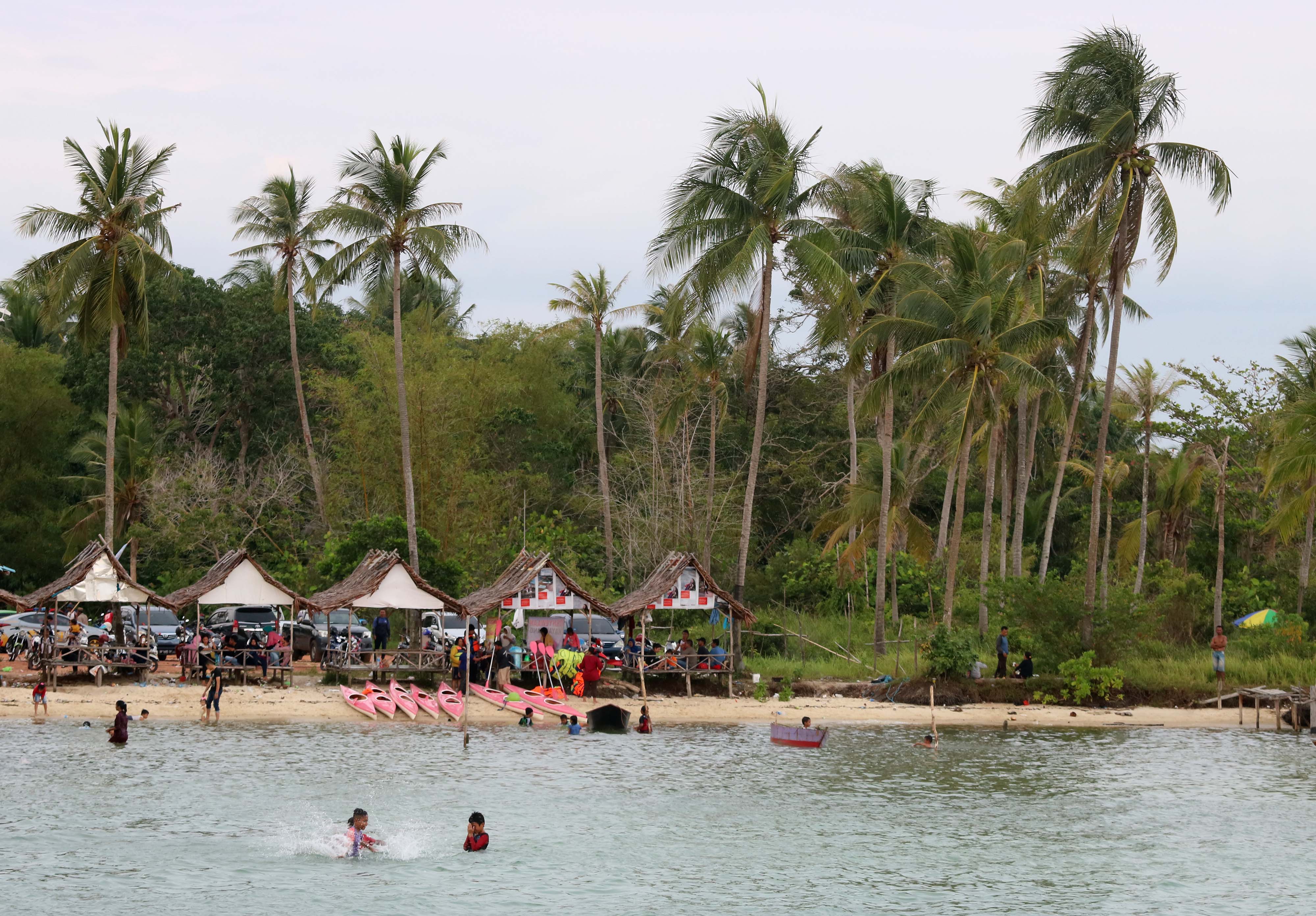 Pengunjung menikmati suasana pantai Tanjung Siambang Pulau Dompak Minggu (15/10) lalu.