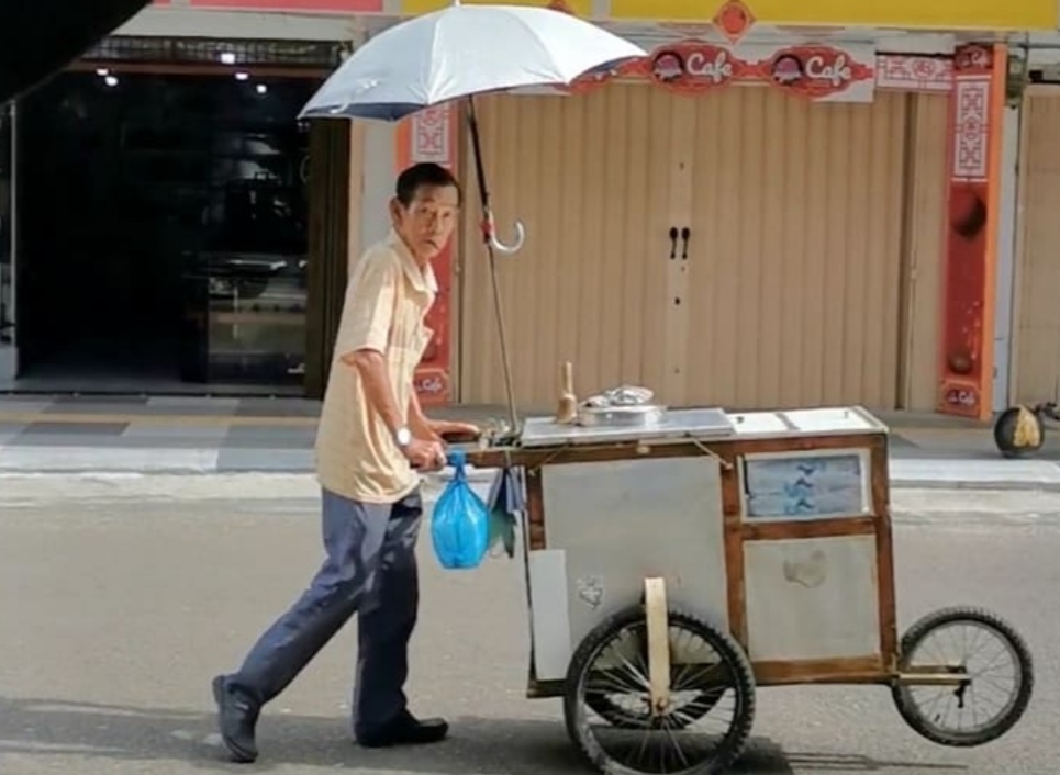 Ahua menggunakan gerobak khas menjajakan es krim jagung di kawasan Kota Lama Tanjungpinang.