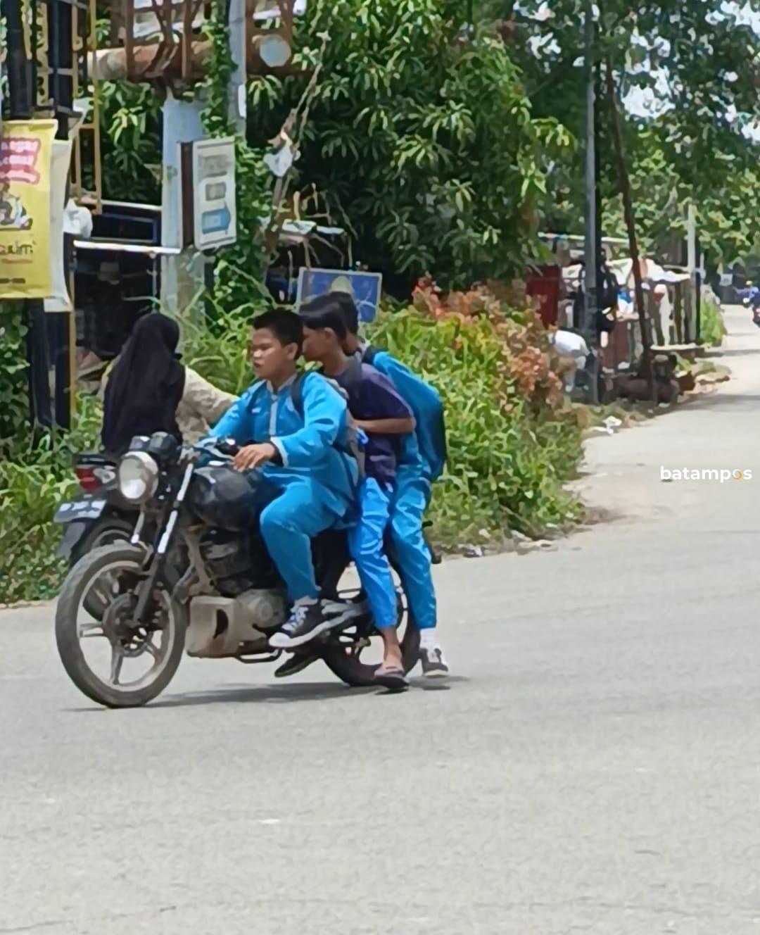 Siswa SMP berkendara bonceng tiga di simpang Kaveling Nato Sagulung.