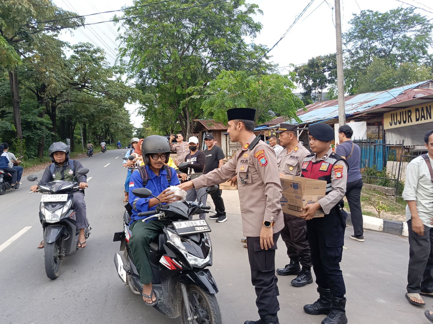 Aksi berbagi takjil polisi dan kelompok umat beragama di Batuaji. Foto: Eusebius Sara