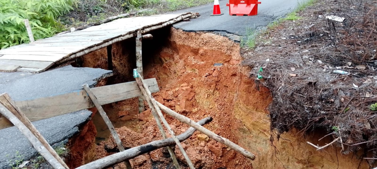 Kondisi jalan di Desa Kelumu yang terputus akibat tanah longsor dikarenakan curah hujan deras, Minggu (23/3).
