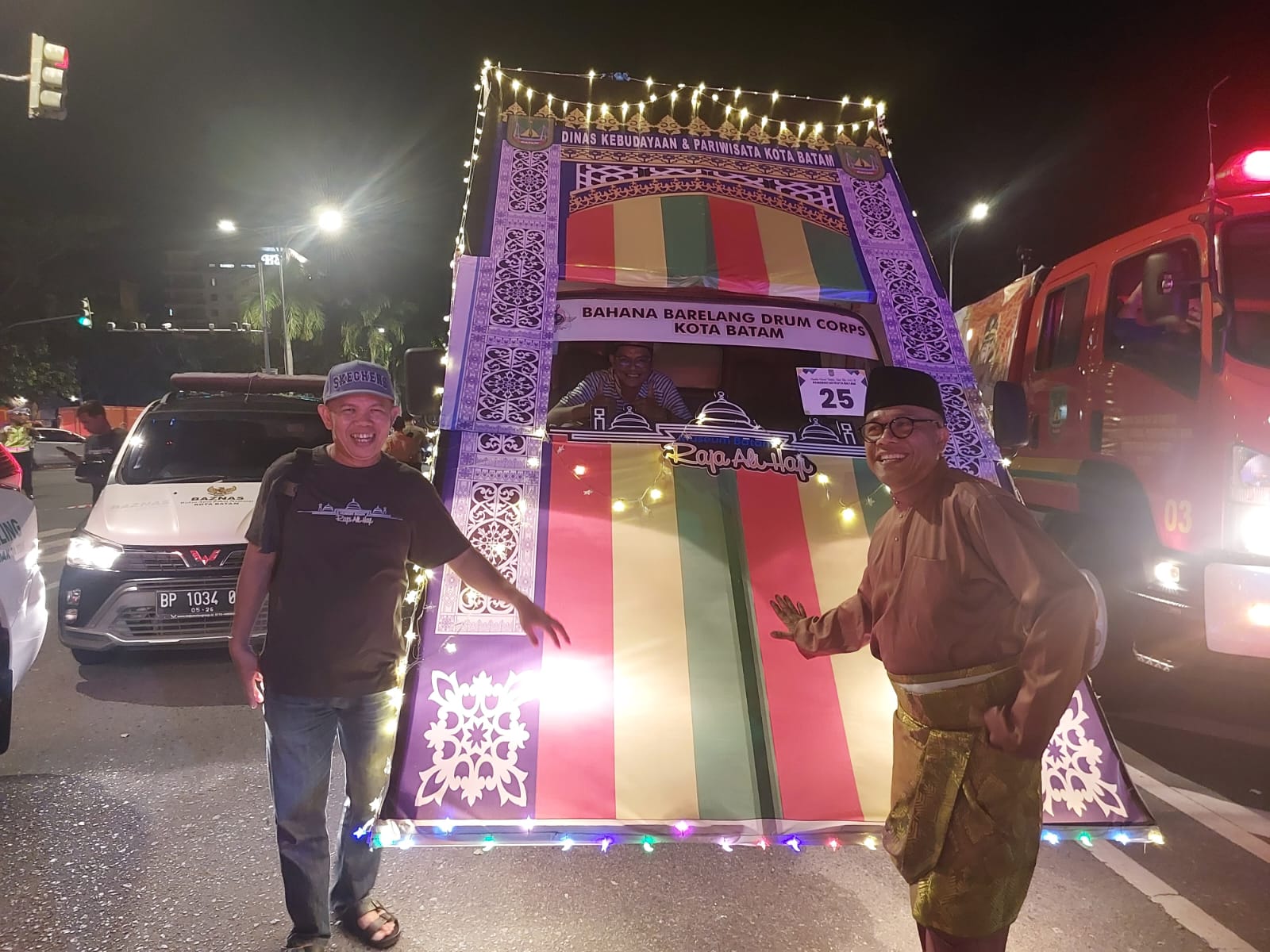Kepala Disbudpar Batam, Ardiwinata (kanan) di depan mobil hias bertema pasak yang menyemarakkan pawai takbir dan lomba mobil hias tingkat Kota Batam, Minggu (30/3/2025) malam.