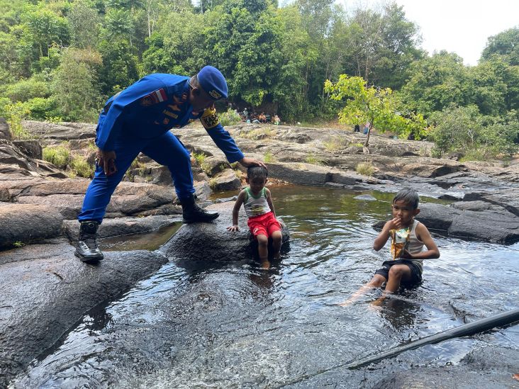 Kasat Polairud Polres Anambas, Iptu Parlindungan Hasibuan memberikan himbauan kepada dua orang anak kecil yang sedang bersantai di Air Terjun Temburun.