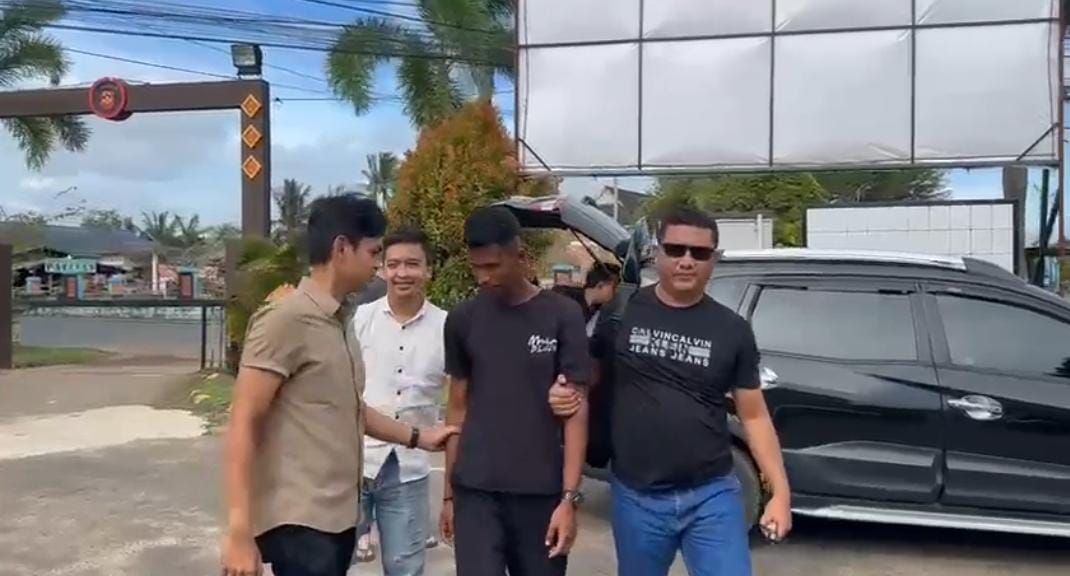 Pelaku yang mengaku-ngaku sebagai anggota polisi digiring polisi dari Polsek Bintan Timur setelah diamankan di tempat kerjanya.