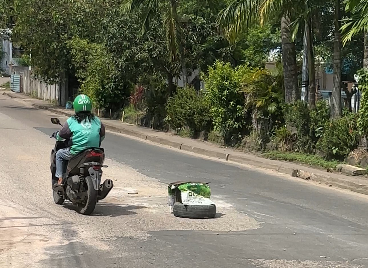 Jalan rusak di depan RSBK Seraya ditutupi ban bekas.