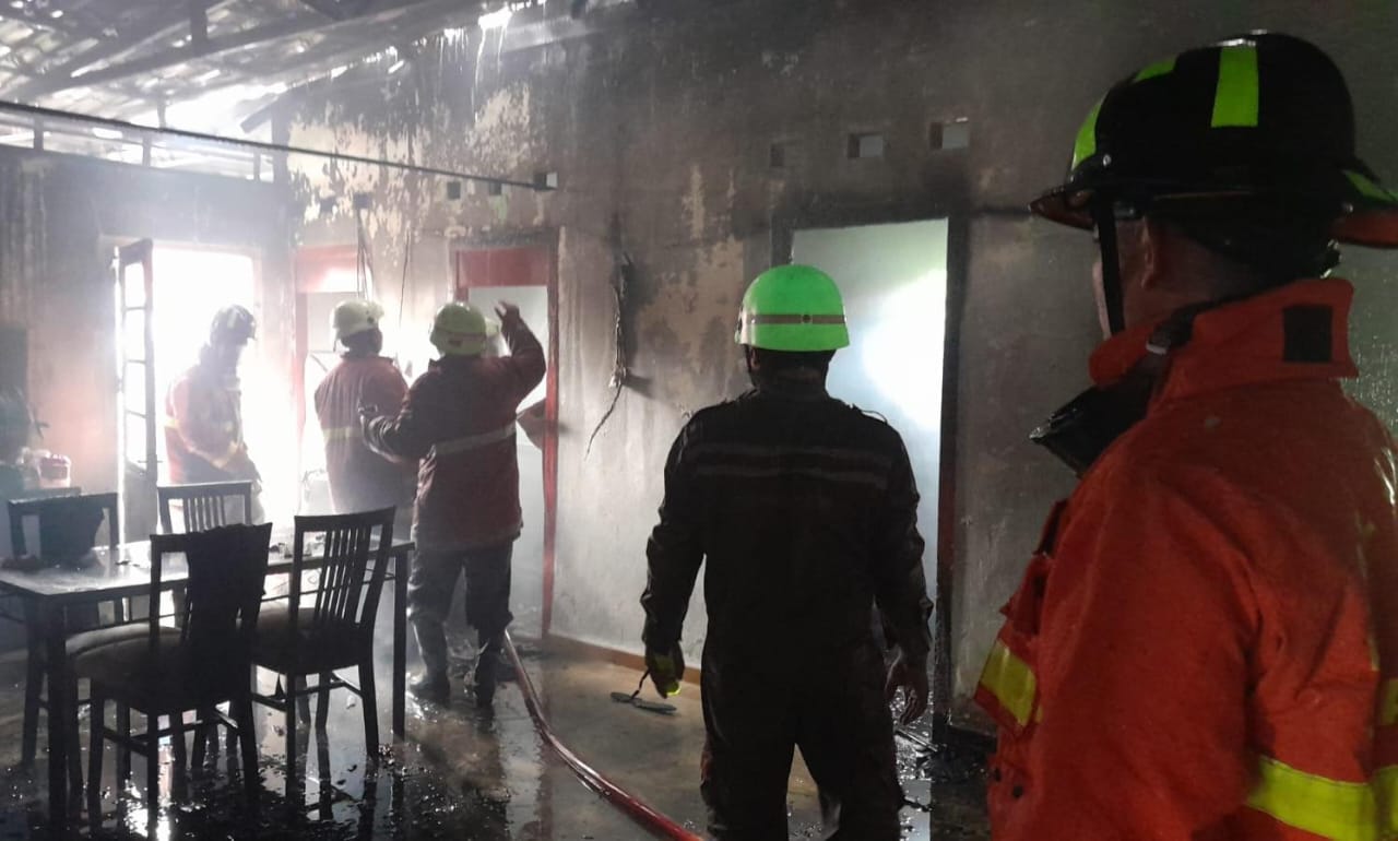 Petugas pemadam kebakaran berusaha memadamkan api di rumah dinas kompleks pegawai PPLP Tanjunguban pada Selasa (22/4/2025).