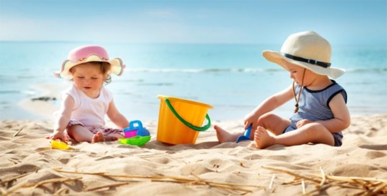 ILUSTRASI. Dua anak perempuan beraktivitas di pantai dengan mengenakan topi  berpinggir lebar.