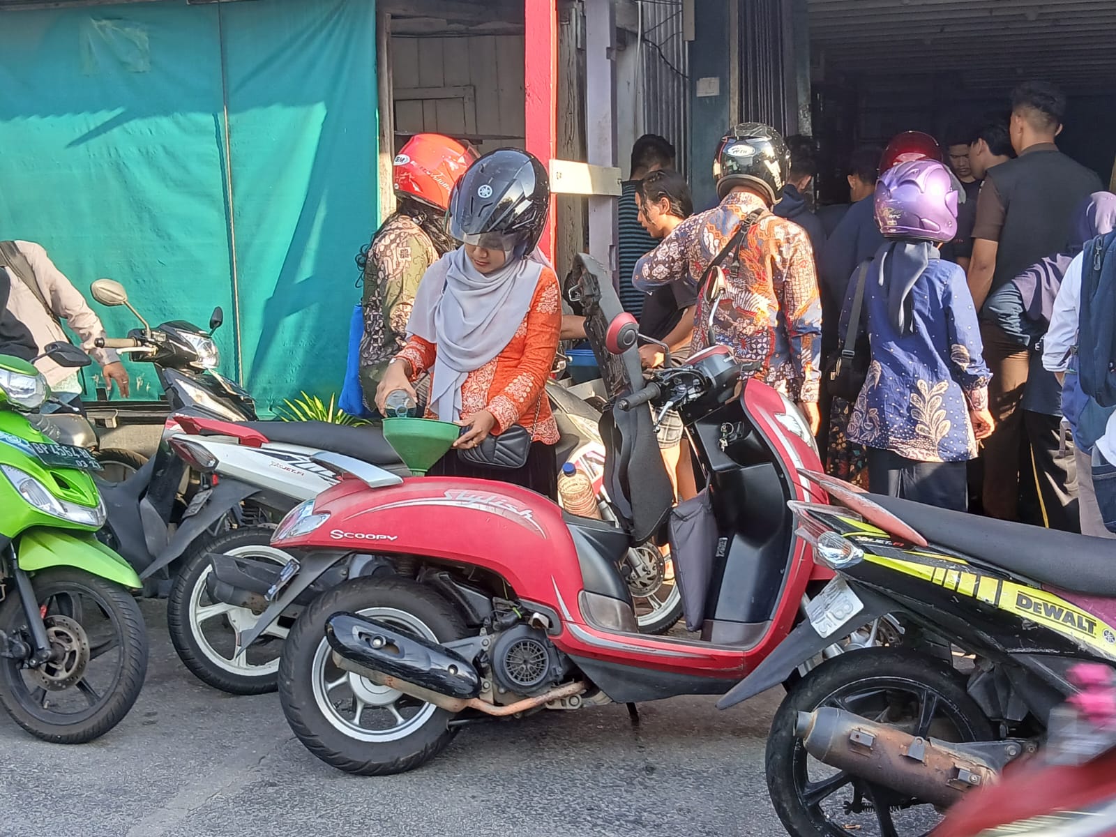 Terlihat seorang ibu-ibu sedang mengisi bahan bakar minyak (bbm) jenis pertalite ke dalam tangki sepeda motor. Pasokan bbm di Anambas kembali tersedia usai alami kelangkaan selama sepekan.