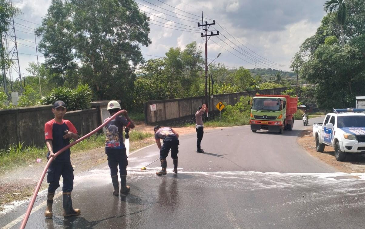 Tim Damkar melakukan penyemprotan air di jalan yang terkena tumpahan minyak solar di jalan Korindo, Kelurahan Sei Lekop, Kecamatan Bintan Timur pada Rabu (18/6/2025) pagi.