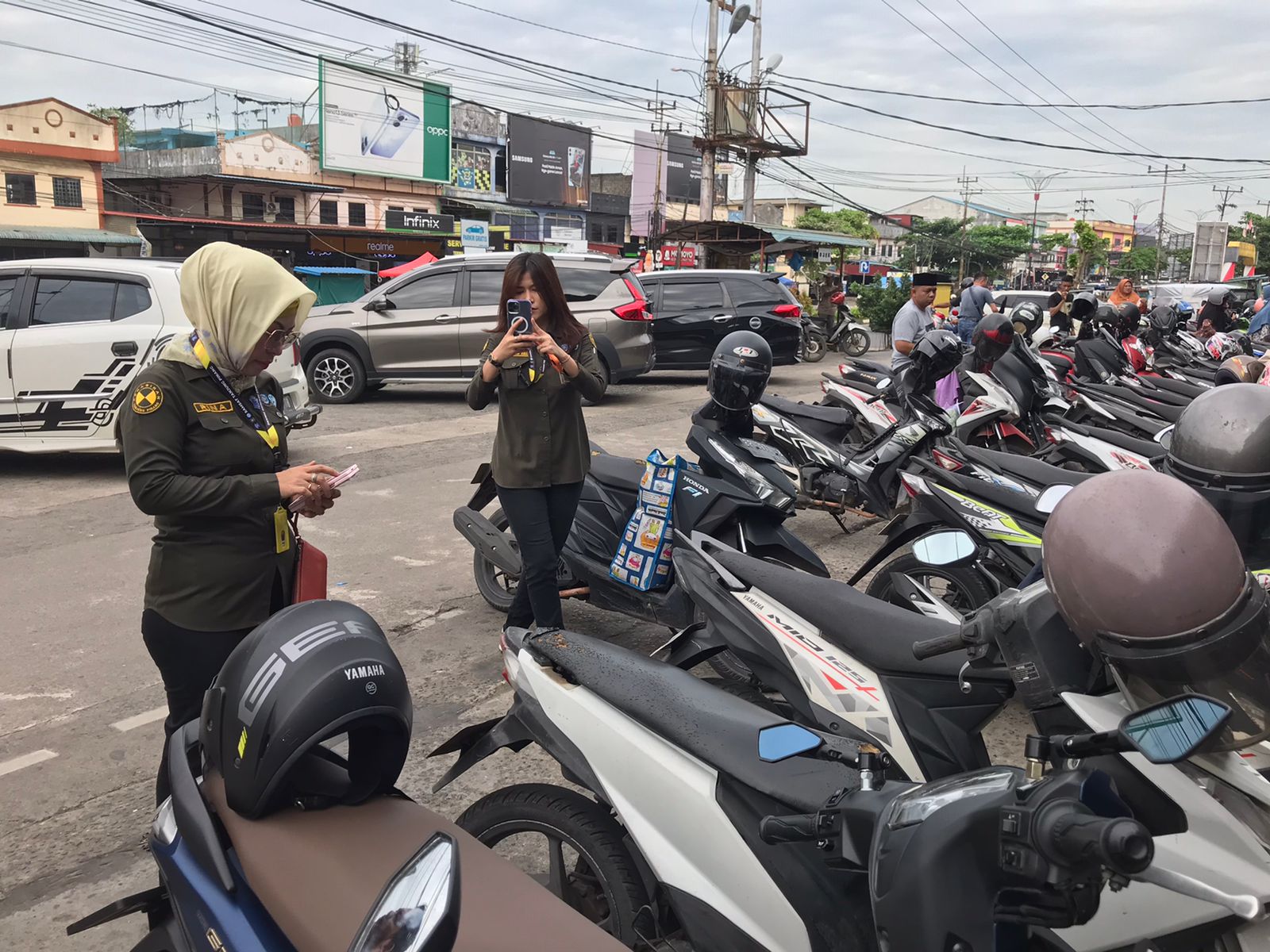 Petugas Samsat saat memberikan surat tagihan di kendaraan penunggak pajak yang terparkir di swalayan Tanjungpinang, Kamis (19/6).