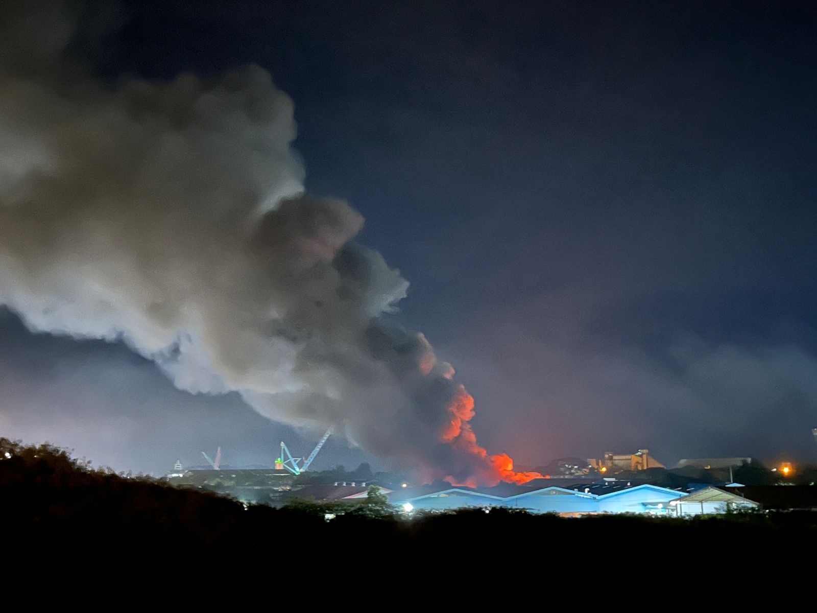 Asap tampak dari kejauhan saat gudang limbah b3 terbakar di Kawasan PT Desa Air Kargo, Kabil, Batam, Senin (23/6) malam.