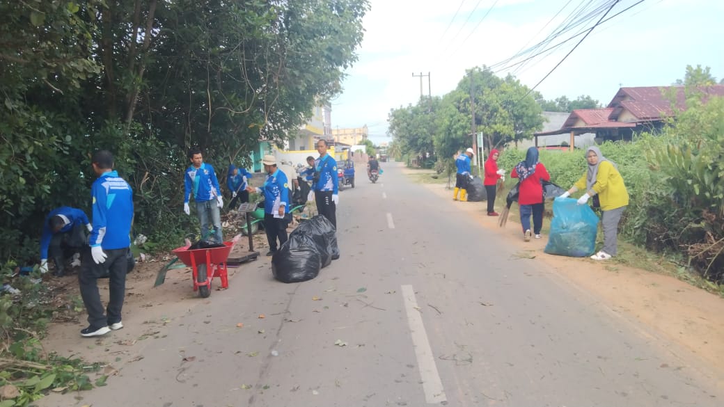 Masyarakat melaksanakan gotong-royong membersihkan sampah di jalan sepanjang jalan utama.