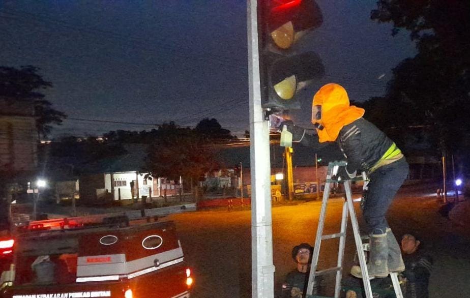 Petugas Damkar mengeksekusi sarang lebah madu di tiang trafic light, Jalan Jalan Permaisuri, Tanjunguban, Kecamatan Bintan Utara, Senin (7/7/2025) petang.