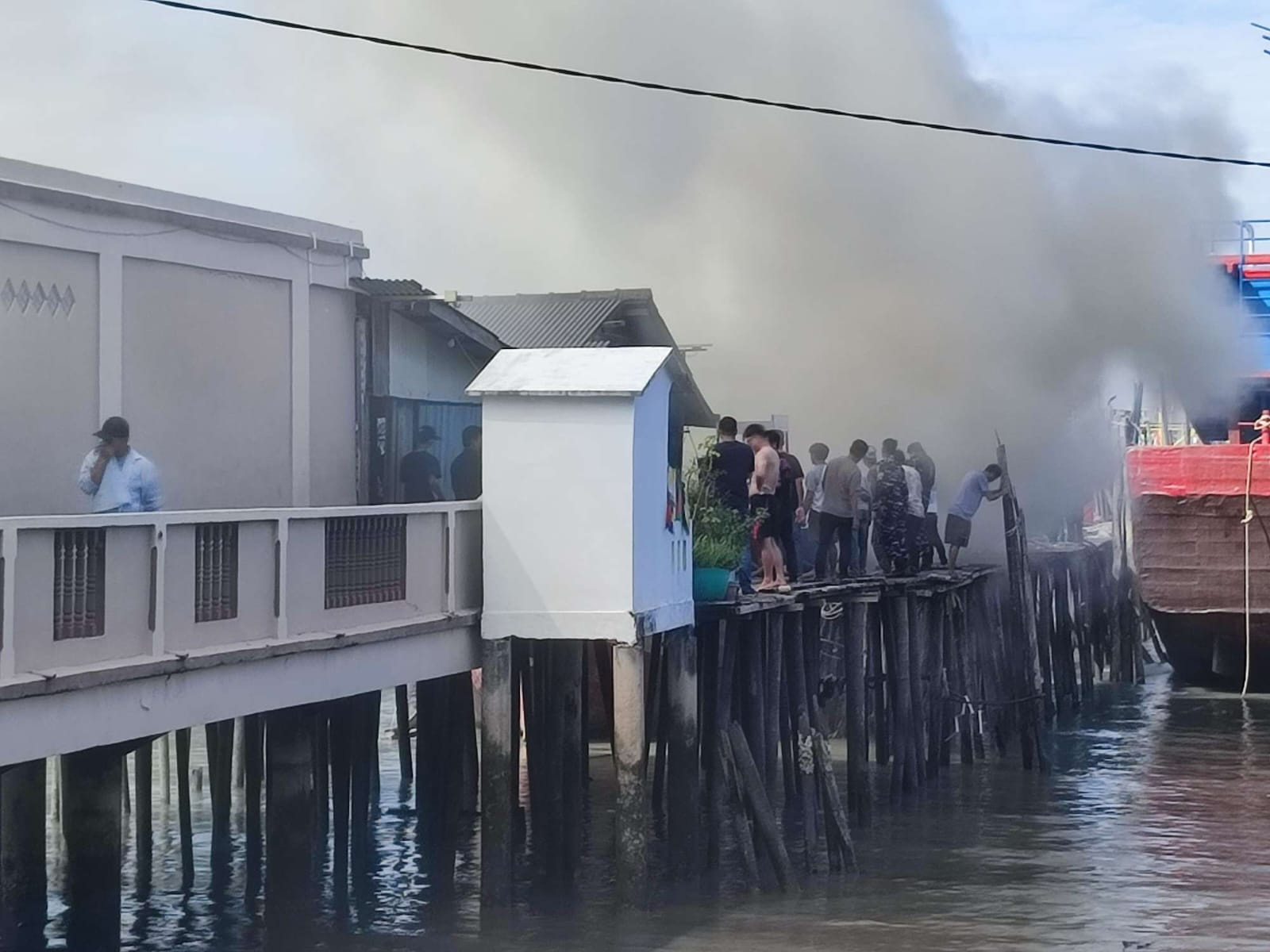 Kapal cumi yang terbuat dari kayu terbakar saat sedang sandar untuk diperbaiki.