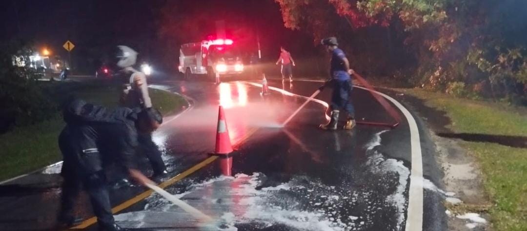 Warga setempat dibantu oleh Petugas Damkar membersihkan jalan yang terkena tumpahan solar, Minggu malam (13/7).