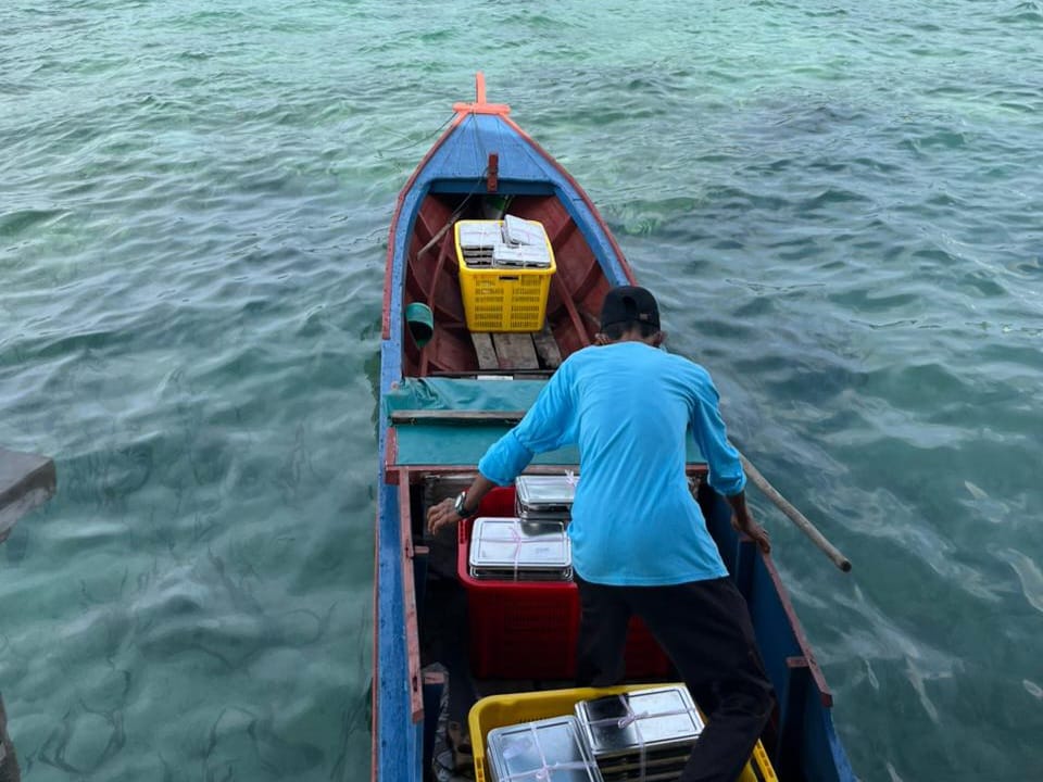 Petugas SPPG Siantan Tengah sedang hendak mengantar paket MBG ke SD Negeri 003 Air Sena dengan menggunakan pompong.