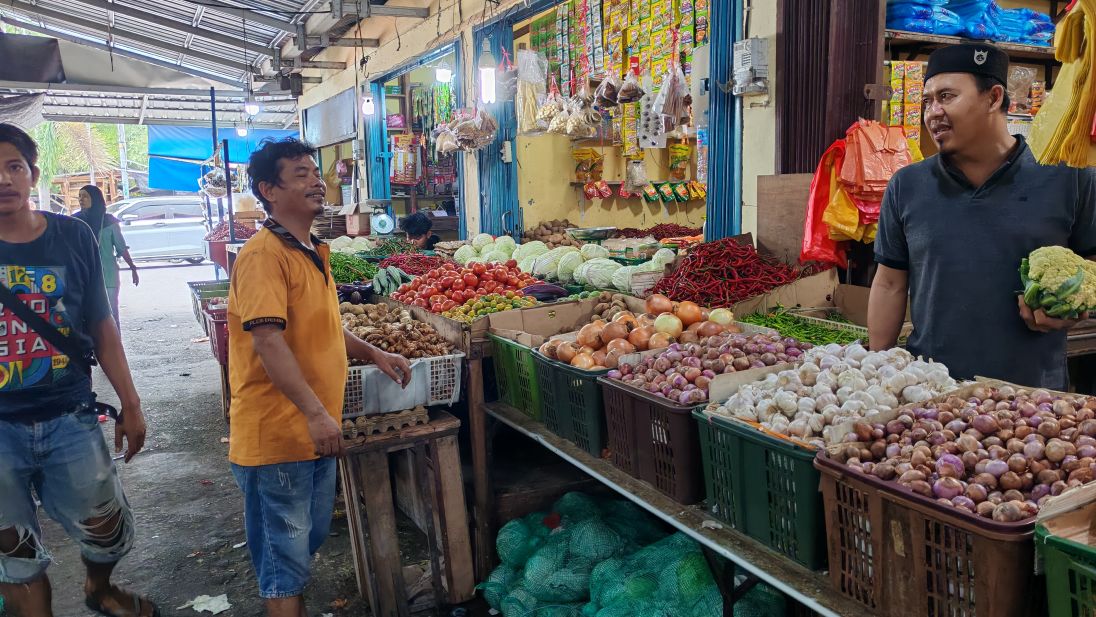 Seorang pedagang sayuran di Pasar Puan Maimun sedang melayani pembeli.