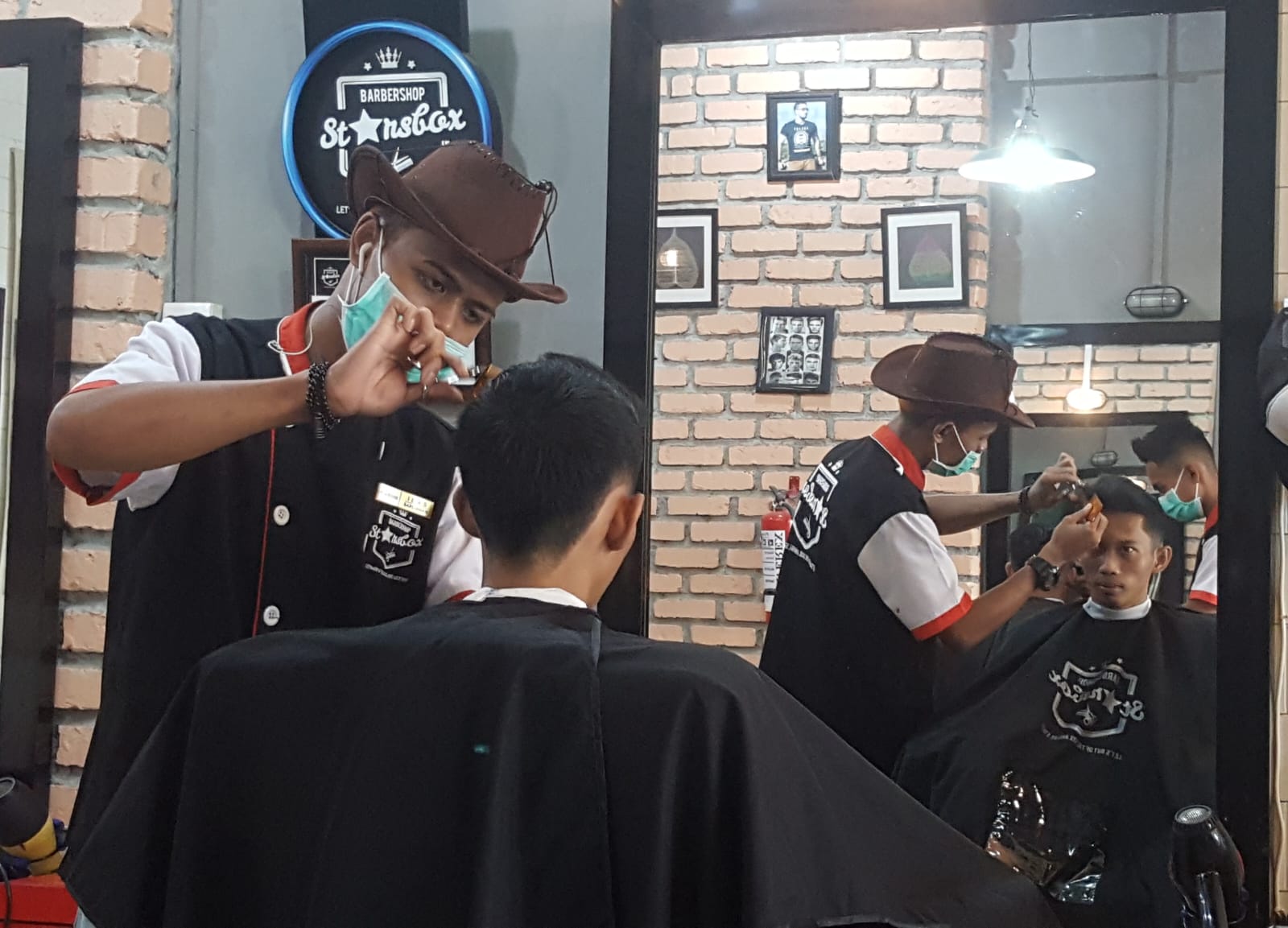Barbermen menata rambut klien di Starsbox Tanjungpinang.