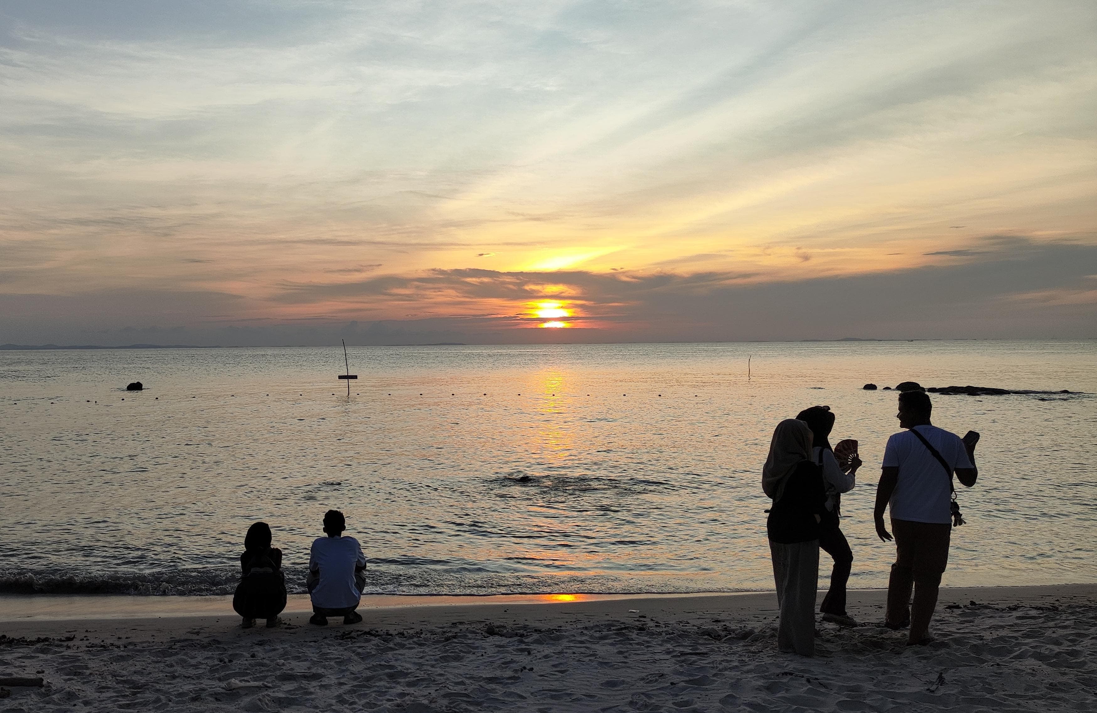 Pengunjung menikmati keindahan senja di Pantai Setumu, Dompak Tanjungpinang.