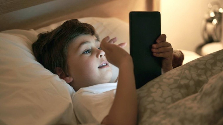 ILUSTRASI. Ketergantungan pada gadget bisa menyebabkan anak-anak tidur lebih larut malam.