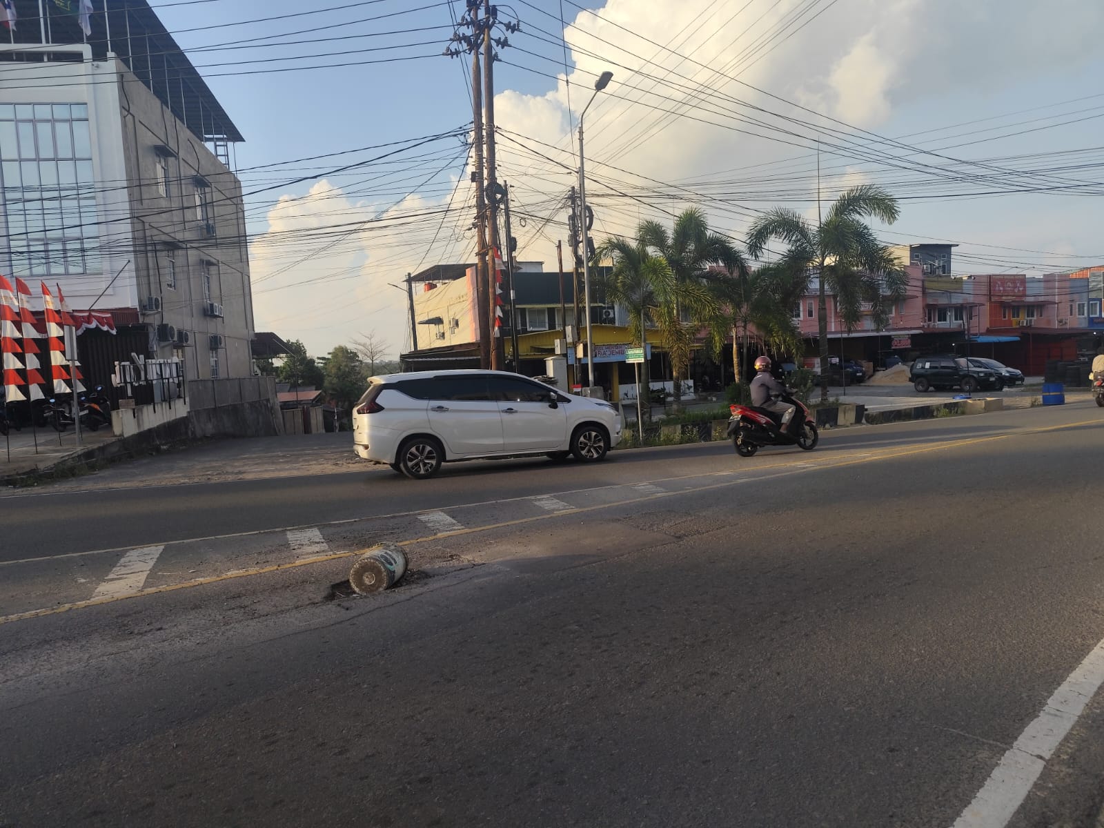 Lubang menganga di Jalan Raja Haji Fisabilillah Tanjungpinang terlihat ditutupi dengan ember sebagai penanda jalan rusak, Minggu (10/8).