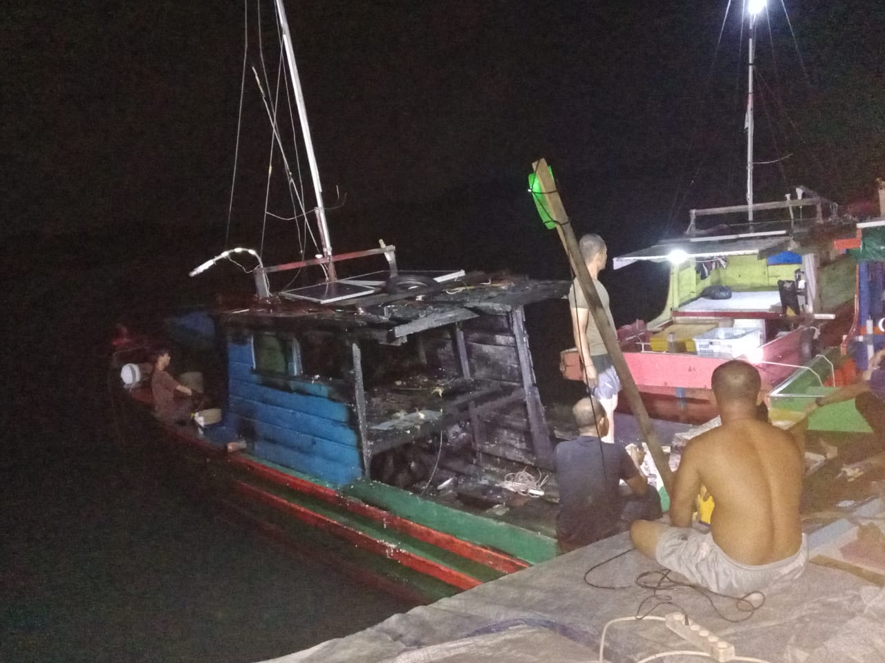 Warga melihat kondisi kapal pompong milik Sabran, warga Desa Belibak yang baru saja terbakar.