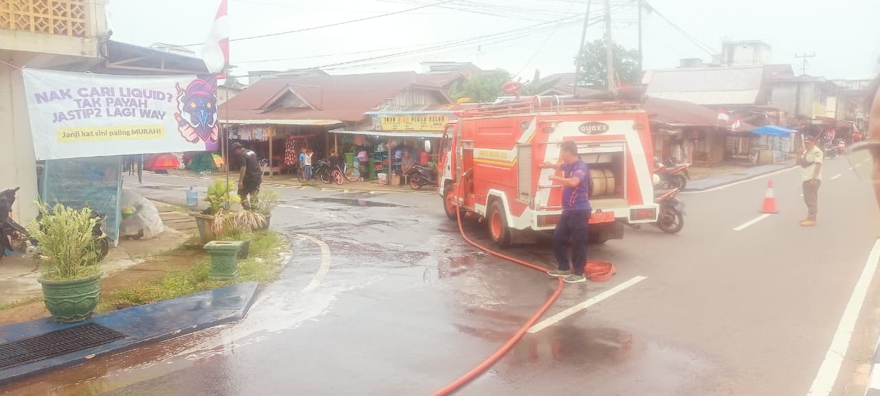 Petugas Damkar dan Satpol PP saat membersihkan jalan yang terkena tumpahan BBM jenis solar, Rabu (13/8).