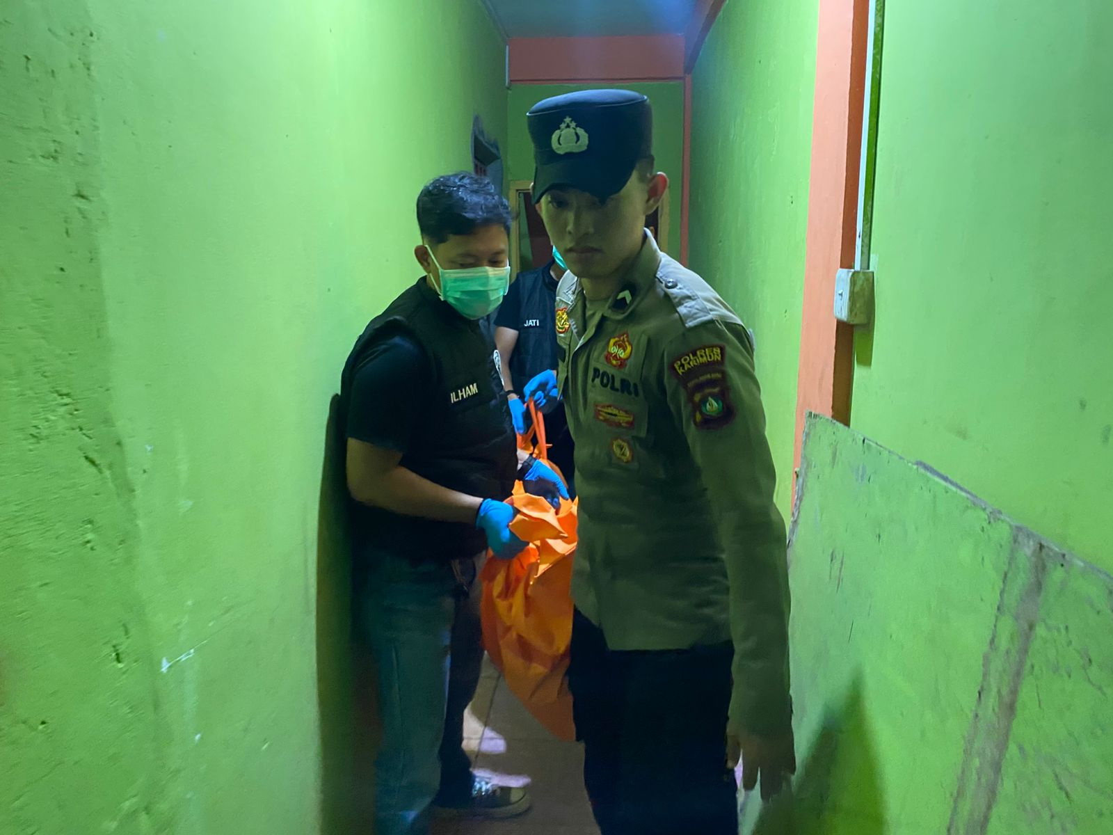 Polisi mengevakuasi mayat penghuni kos.