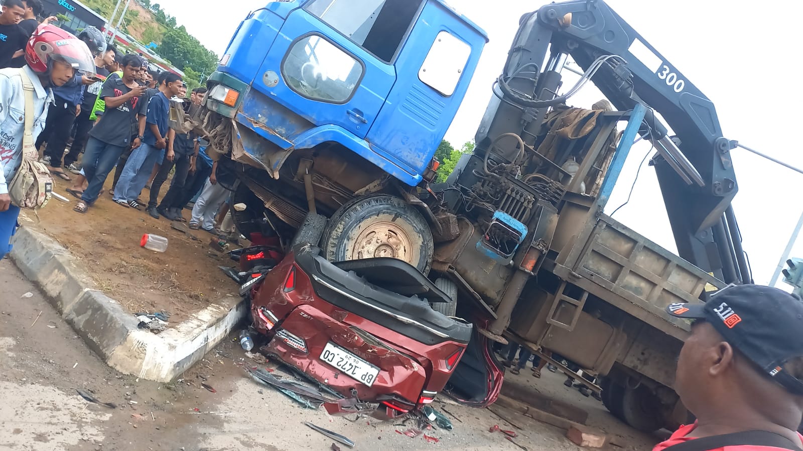 Trailer crane menabrak dan menimpa satu unit mobil sedan dan motor saat kecelakaan di Tiban Center, Batam.