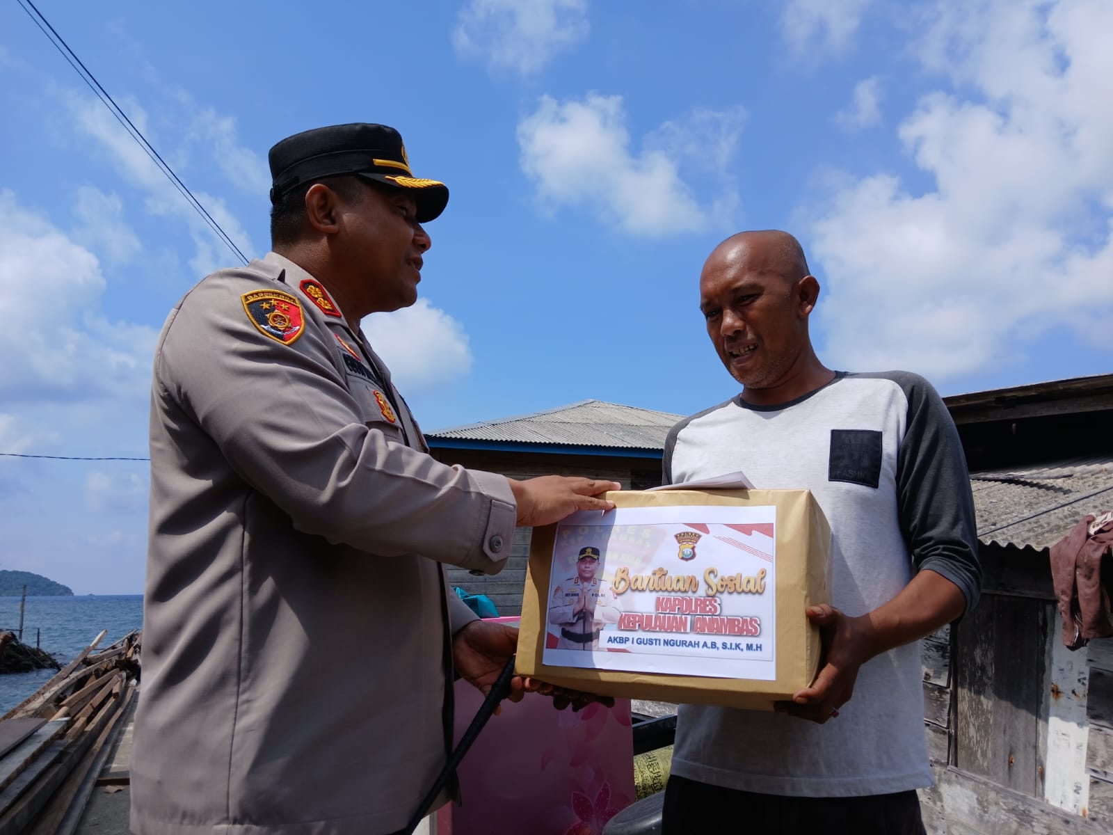 Kapolres Anambas, AKBP I Gusti Ngurah Agung Budianaloka saat menyerahkan bantuan kepada korban, Masruhadi yang rumahnya ambruk dihantam gelombang.