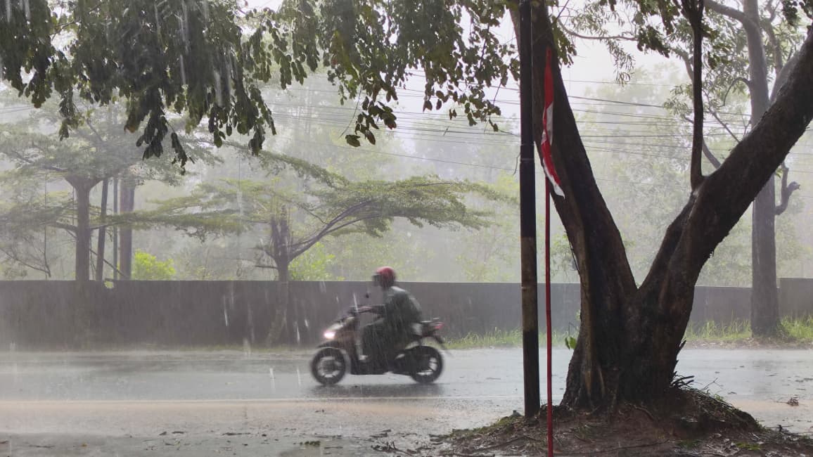 Warga Tanjungpinang menerobos hujan di pagi hari, Senin (1/9).