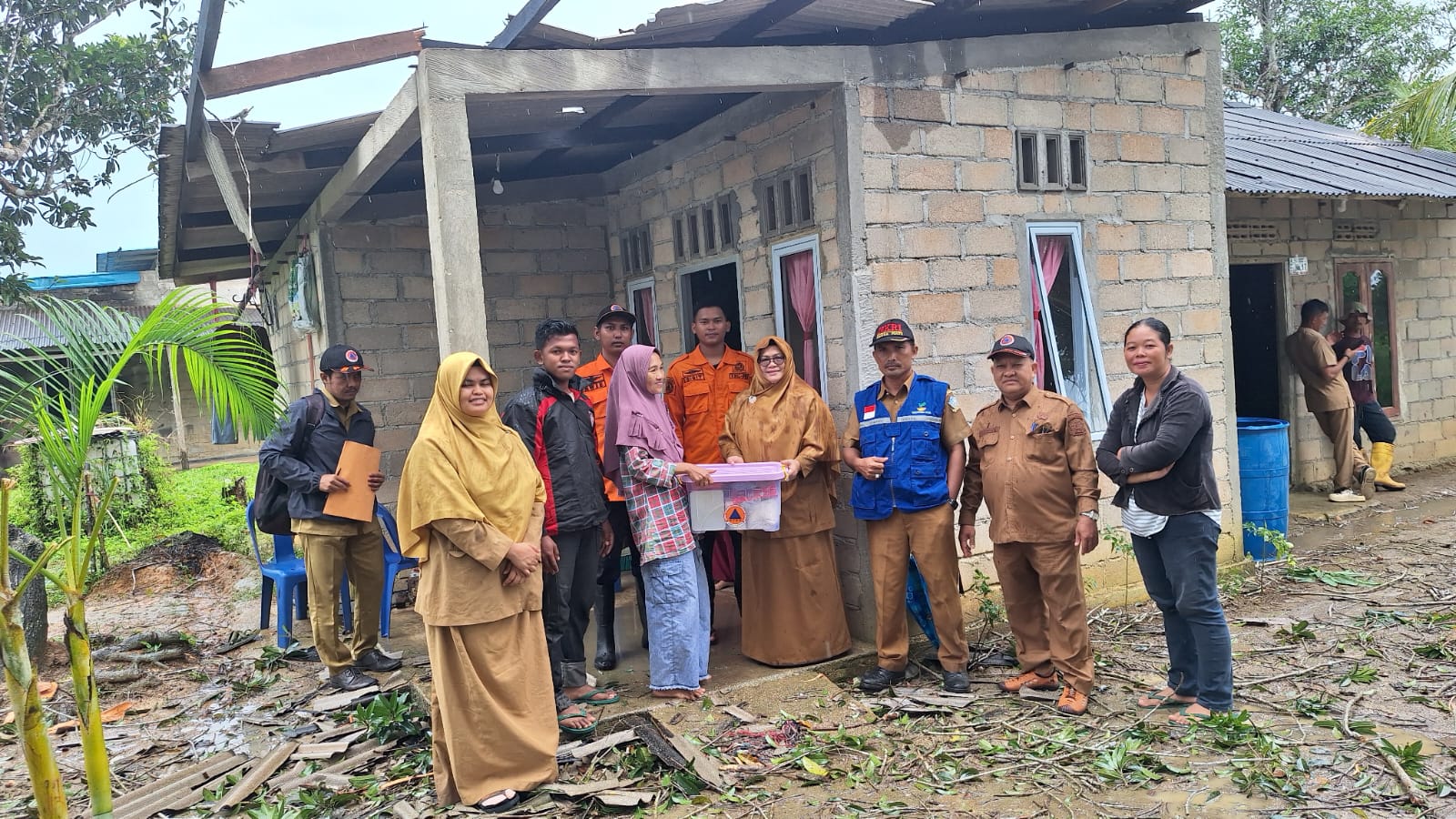 Kepala Pelaksana BPBD Bintan, Ramlah menyerahkan bantuan logistik sekaligus verifikasi kerusakan rumah hunian masyarakat korban bencana cuaca ekstrem di Kampung Jawa RT 003 RW 001 Desa Toapaya.