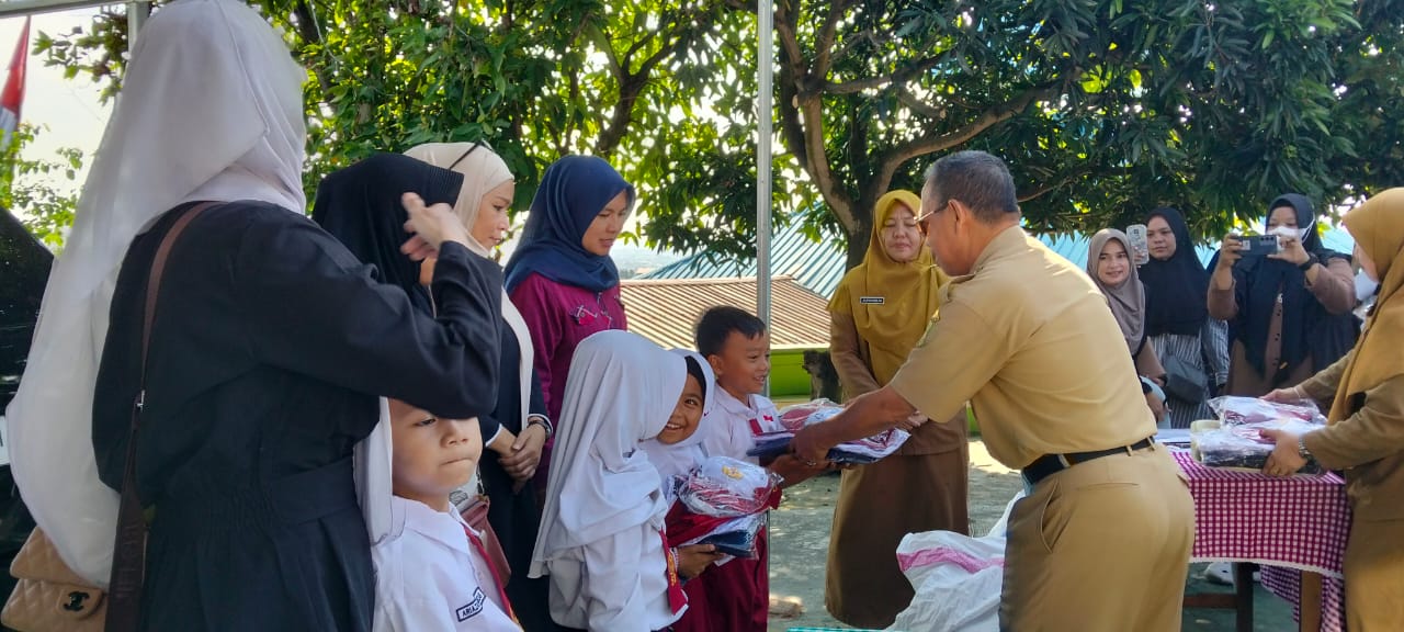 Kepala Dinas Pendidikan (Disdik) Kota Batam, Hendri Arulan menyerahkan seragam gratis kepada siswa di salah satu SD di Kecamatan Sekupang.