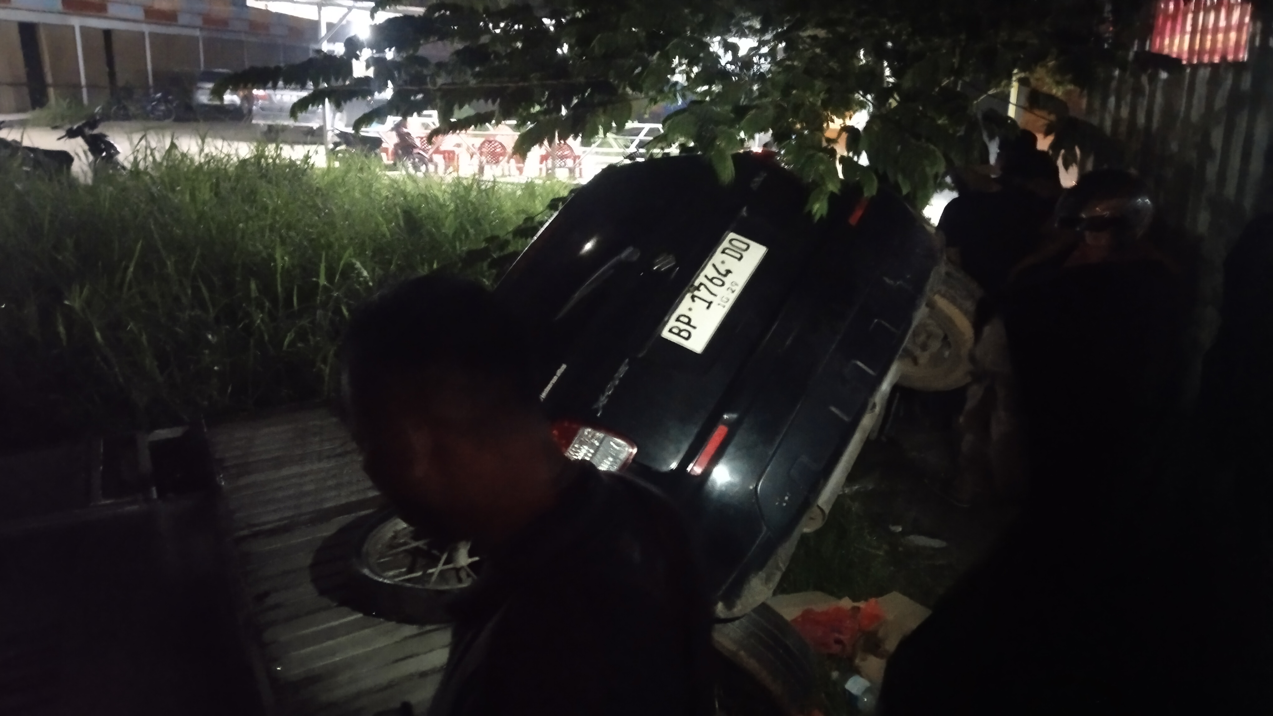 Mobil Suzuki terbalik ke selokan usai menabrak gerobak gorengan di daerah Marina, Batam.