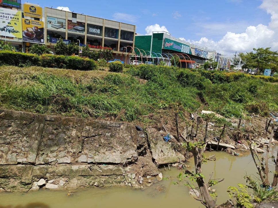 Tanggul jebol, drainase induk pinggir jalan R Suprapto Sagulung mulai longsor.