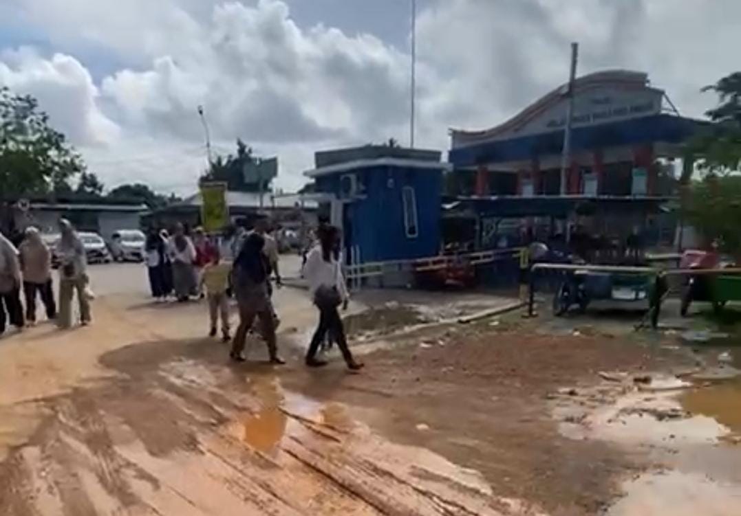 Wisatawan yang tiba di Pelabuhan ASDP Tanjunguban harus berjalan dengan hati-hati di area parkir bus pariwisata yang becek dan berlubang.