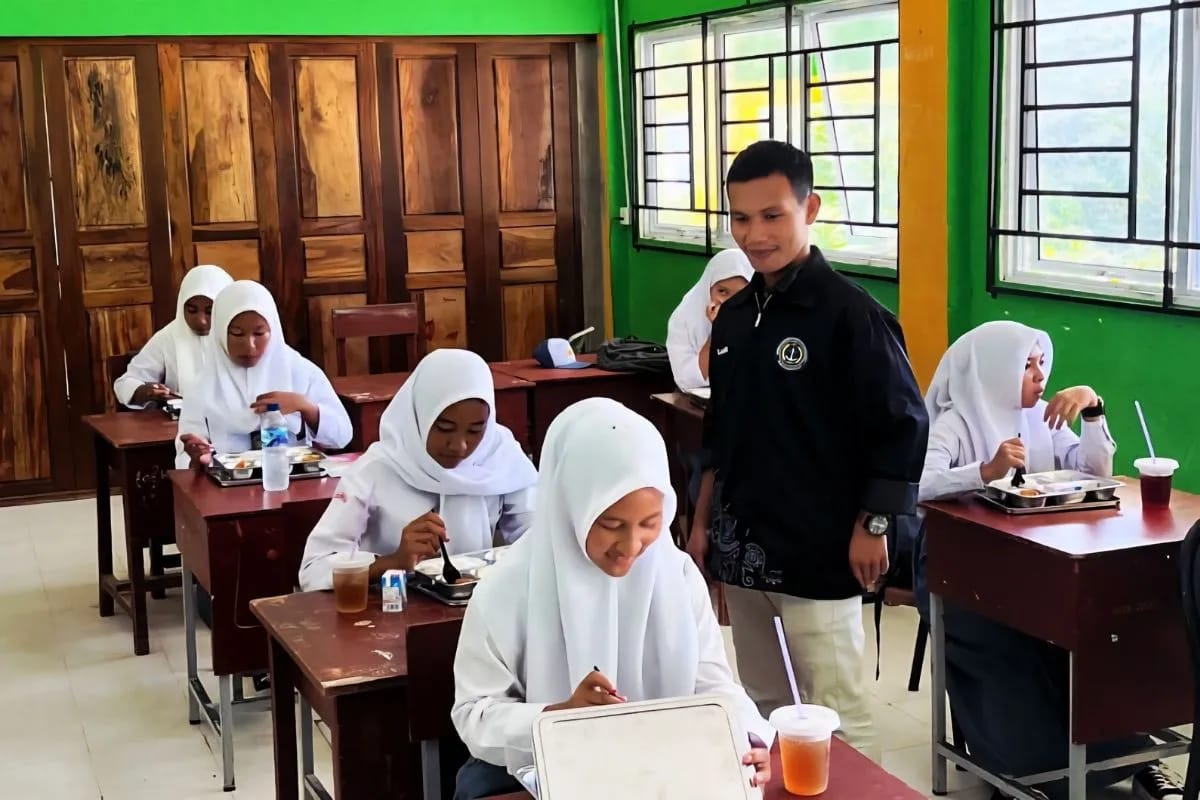 Petugas SPPG Air Asuk saat mendistribusikan makanan bergizi gratis kepada siswa di Kecamatan Siantan Tengah.