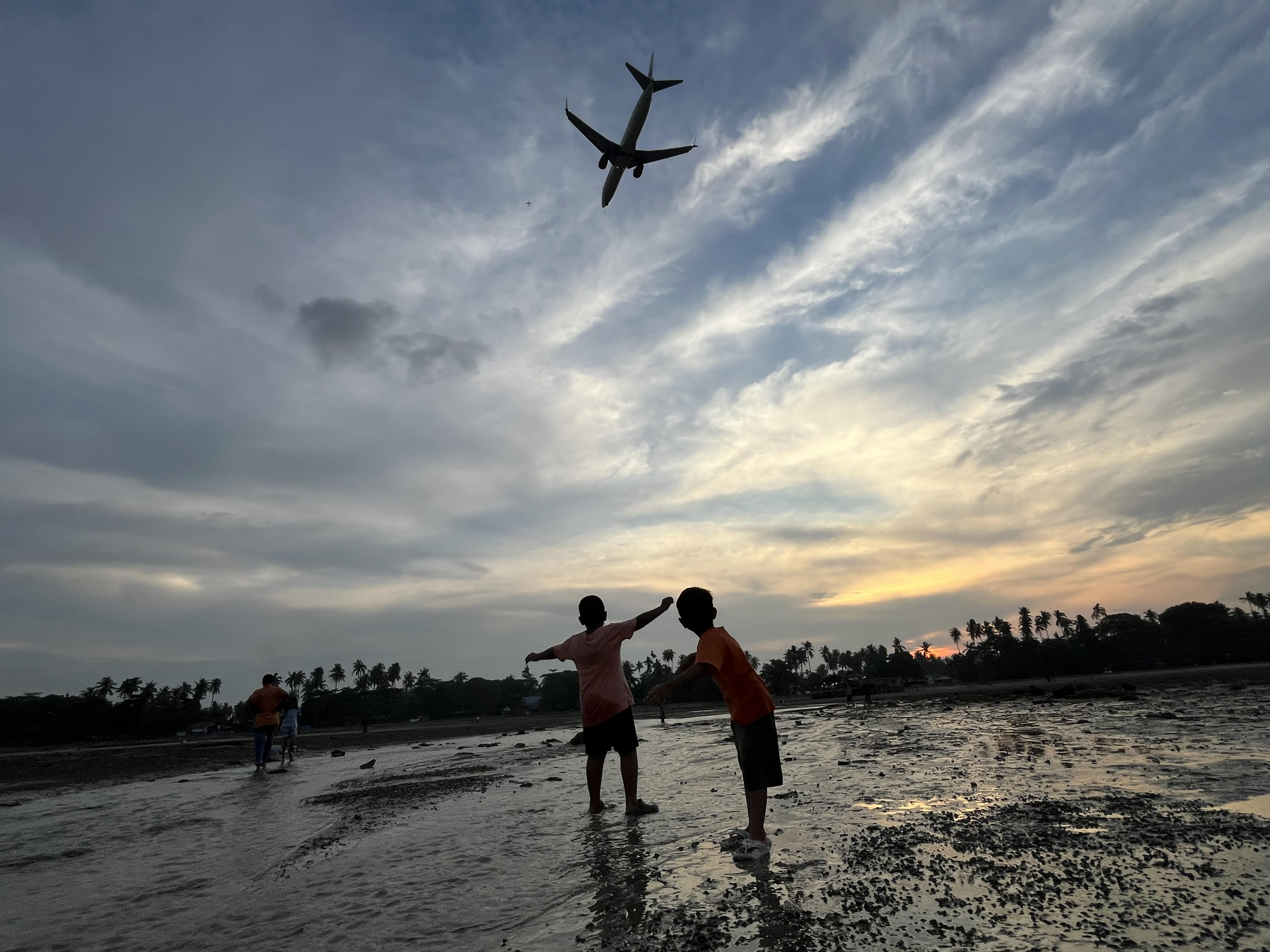 Warga menikmati pantai yang air lautnya surut.
