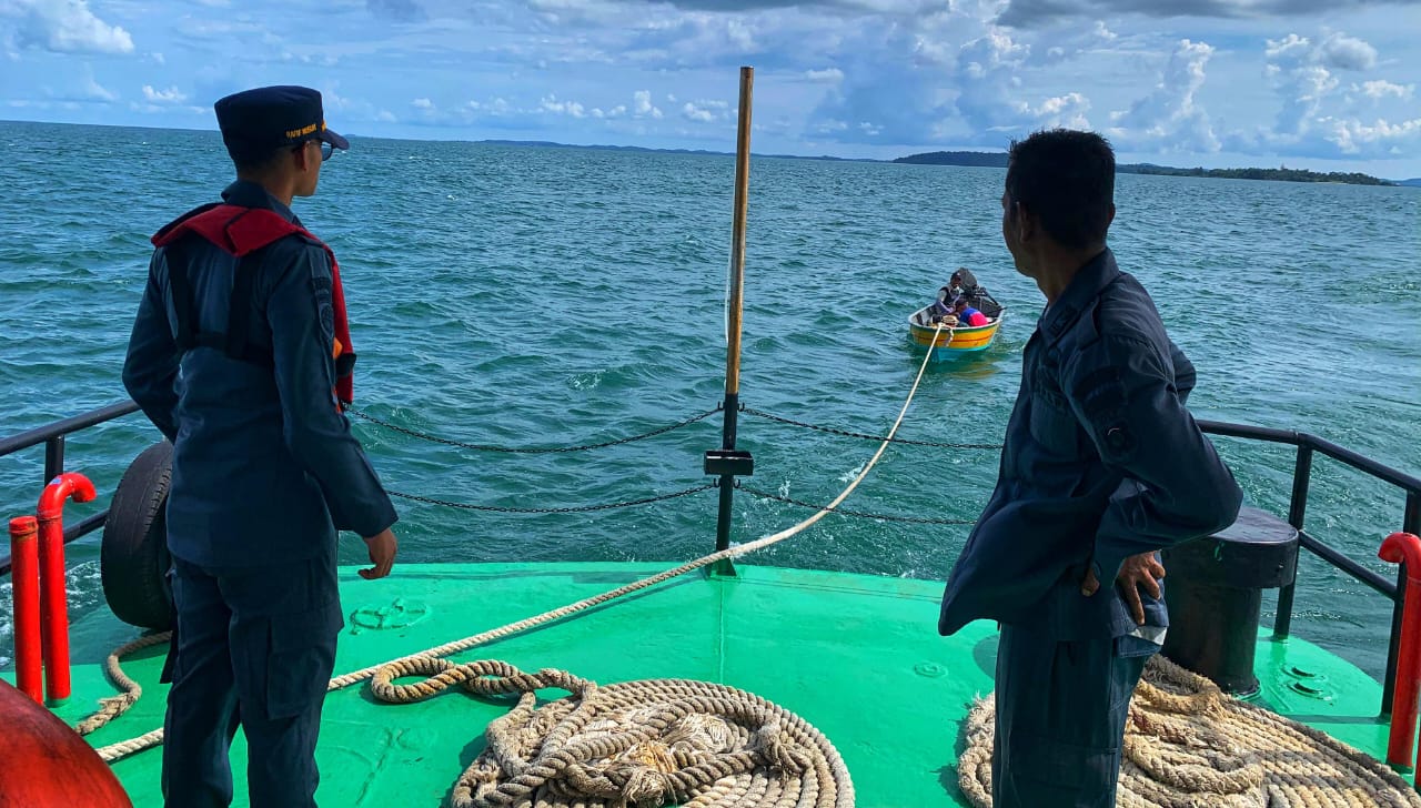 Petugas dari KN 406 menarik sampan nelayan setelah kehabisan bahan bakar minyak di perairan Selat Riau, Senin (20/10).